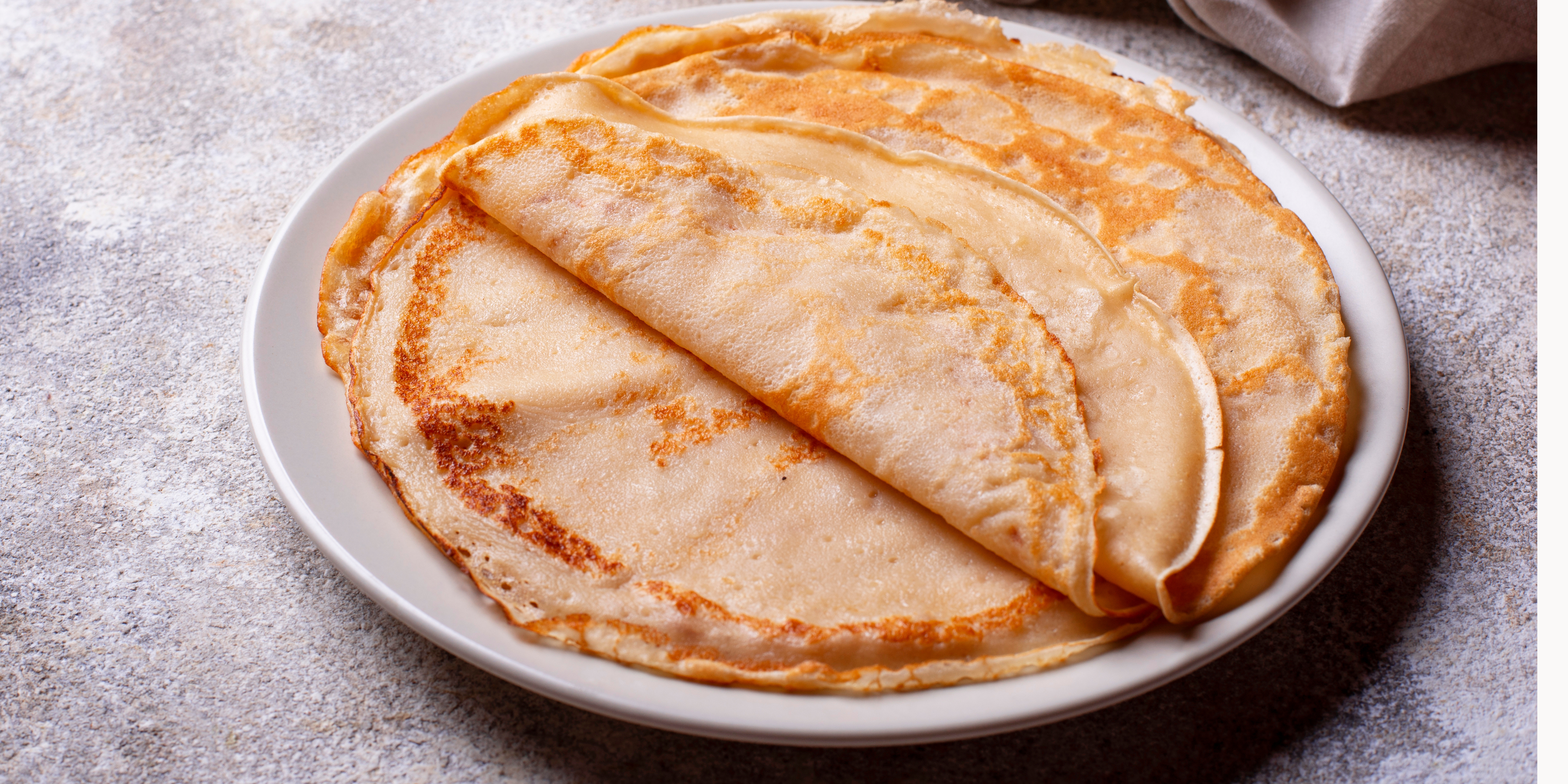 Chandeleur: Recette de crêpes bio et saines 1 Une assiette de crêpes bio et saines dorées et moelleuses empilées les unes sur les autres
